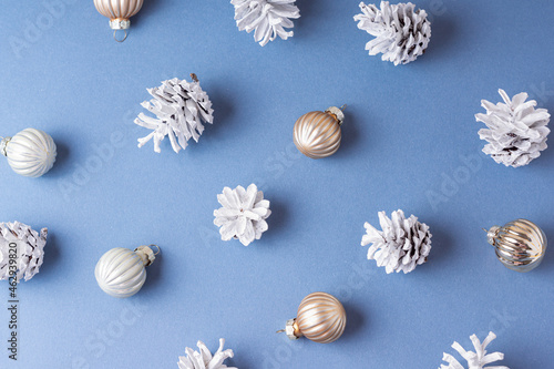 Pine cones and Christmas balls on blue background. Pattern. Christmas decorations. Happy New year and Christmas 2022 celebration
