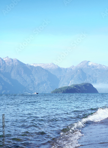 small boat sailing between mountains