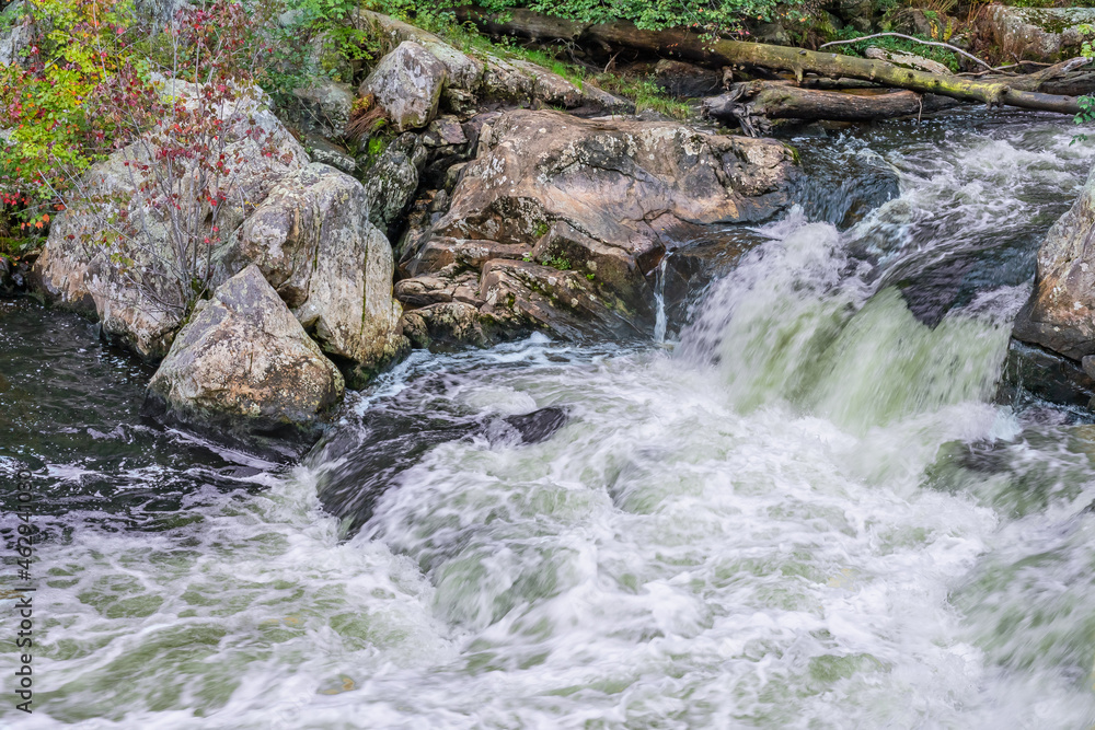 Fototapeta premium Water jets of a waterfall on the Ammonoosuk River among granite stones flowing down from Mount Washington, New Hampshire, USA.