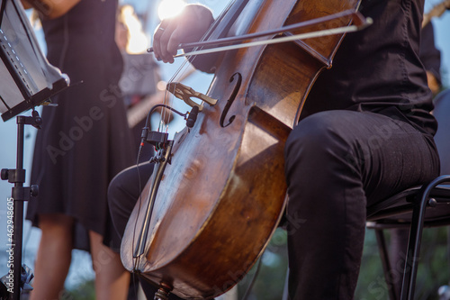 Male musician playing cello in orchestra on the street