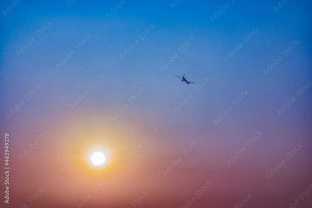 Flying aeroplane in the sunsetting sky
