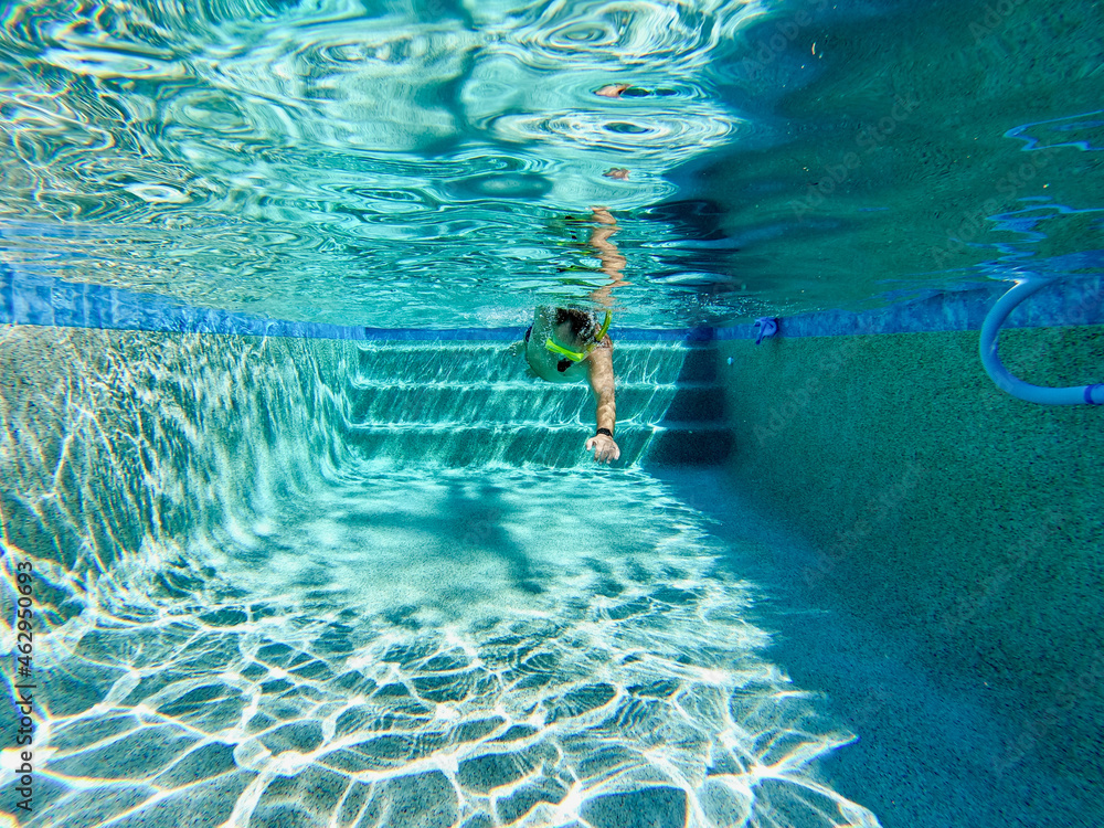 A man swimming freestyle in a swimming pool in on a sunny day in Florida.