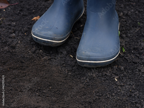 A person wearing boots standing on muddy ground