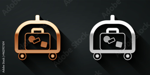 Gold and silver Hotel luggage cart with suitcase icon isolated on black background. Traveling baggage sign. Travel luggage icon. Long shadow style. Vector