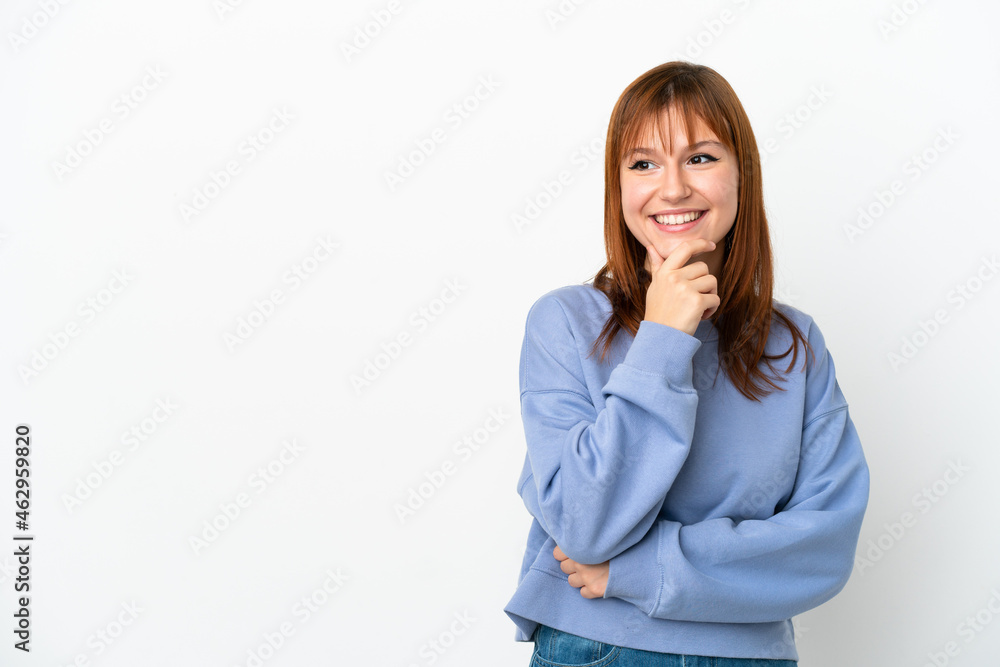 Redhead girl isolated on white background looking to the side and smiling Redhead girl isolated on white background looking to the side and smiling