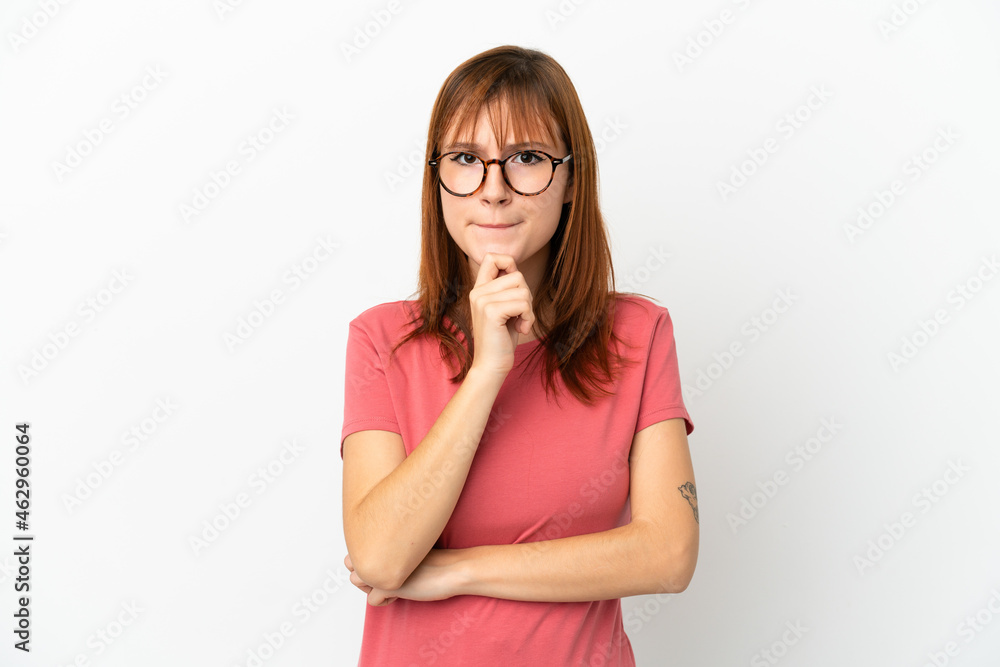 Redhead girl isolated on white background having doubts and thinking Redhead girl isolated on white background having doubts and thinking