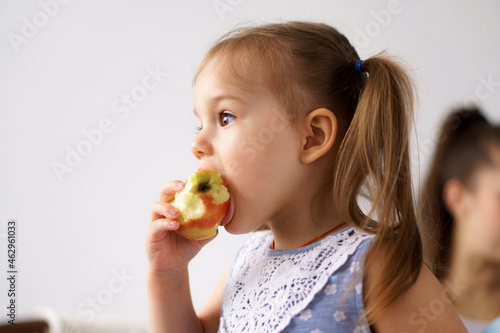 happy cheerful funny kids children with mom eat bite fresh fruits and vegetables at home. family eats lunch oranges, citrus apples bananas. Healthy eating, vitamins, diet, vegetarianism menu concepts
