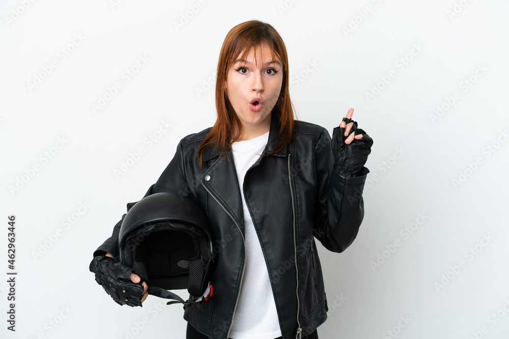 Redhead girl with a motorcycle helmet isolated on white background intending to realizes the solution while lifting a finger up Redhead girl with a motorcycle helmet isolated on white background intending to realizes the solution while lifting a finger up