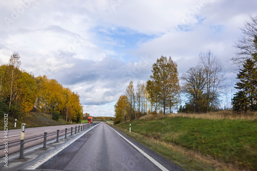 Beautiful scenic view of highway merging with cloudy sky. Autumn background. Sweden. 