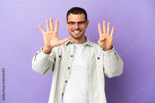 Brazilian man over isolated purple background counting nine with fingers © luismolinero