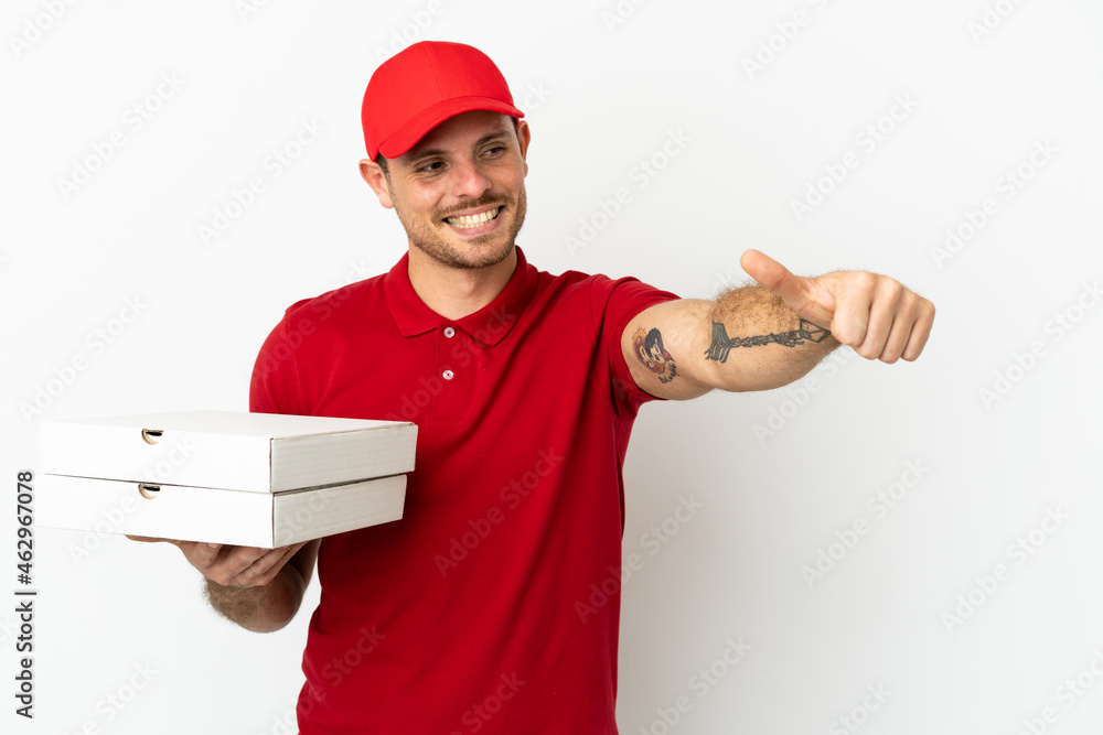 pizza delivery man with work uniform picking up pizza boxes over isolated white wall giving a thumbs up gesture pizza delivery man with work uniform picking up pizza boxes over isolated white wall giving a thumbs up gesture