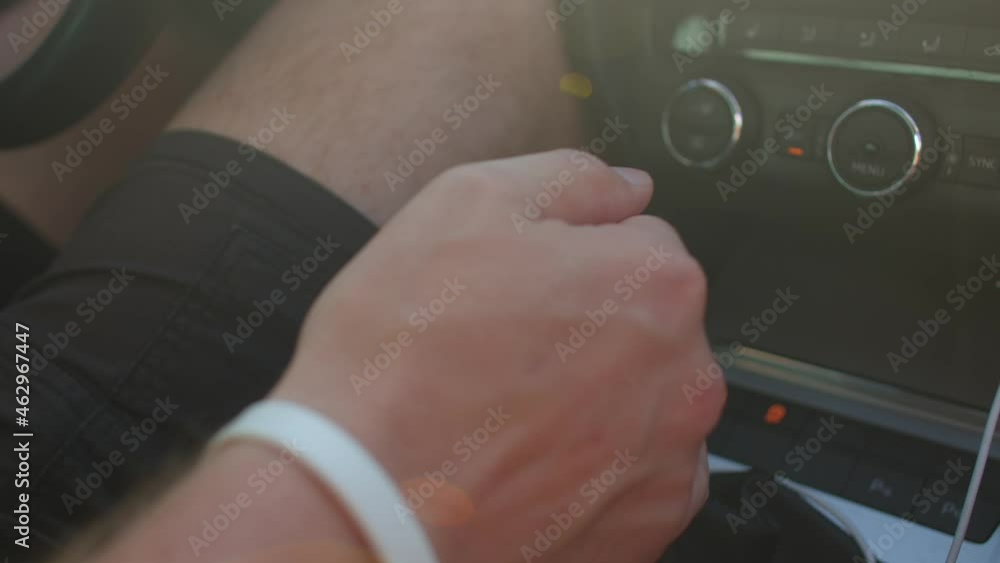 The hand pulls the auto gearshift knob. He changes gears on the fly. Searching for speed change. The hand pulls the auto gearshift knob. He changes gears on the fly. Searching for speed change.