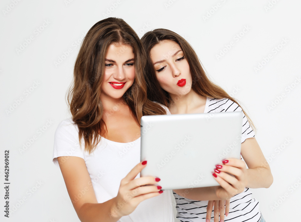 two girls friends taking selfie with digital tablet over white background