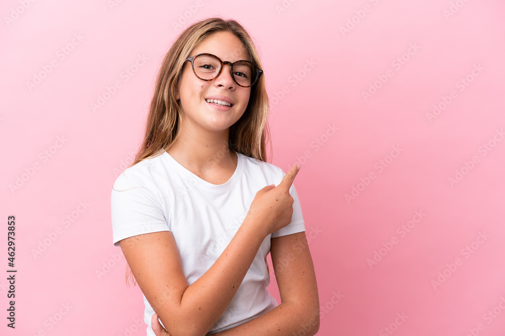 Little caucasian girl isolated on pink background With glasses and pointing side Little caucasian girl isolated on pink background With glasses and pointing side