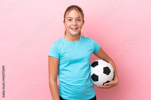 Little football player girl isolated on pink background with surprise facial expression
