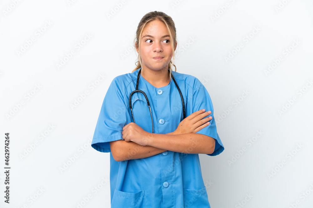 Little caucasian girl disguised as surgeon isolated on white background making doubts gesture while lifting the shoulders Little caucasian girl disguised as surgeon isolated on white background making doubts gesture while lifting the shoulders