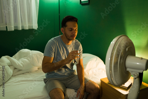 Φωτογραφία Thirsty man drinking water at midnight