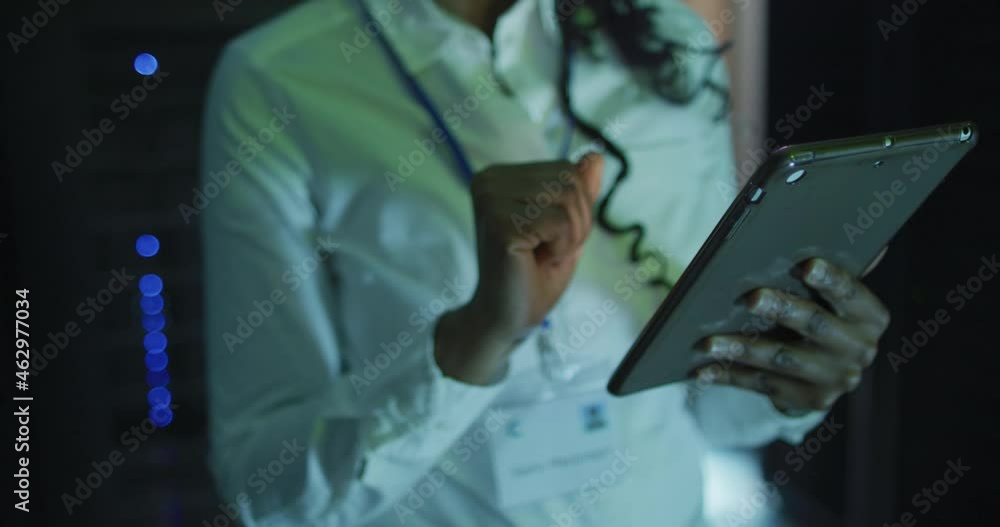 African american female computer technician using tablet working in business server room
