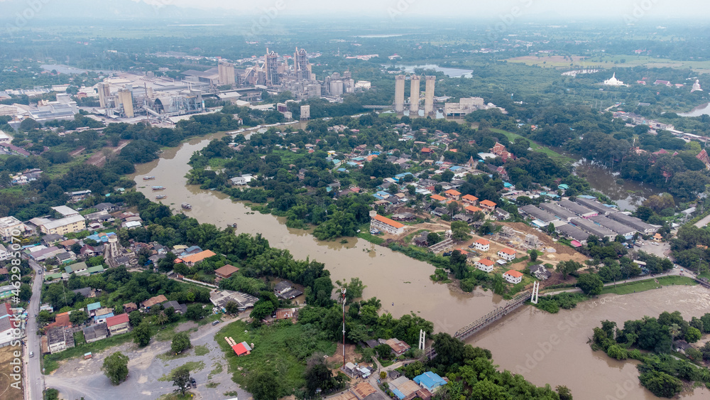 Flood waters overtake a house and rice field at Central of Thailand in 2021. Many buildings are submerged in water. Photo disaster from above view by drone Flood waters overtake a house and rice field at Central of Thailand in 2021. Many buildings are submerged in water. Photo disaster from above view by drone