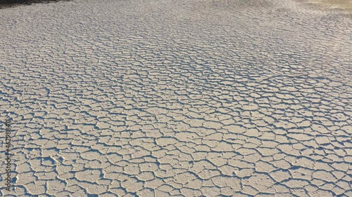 Dry salt flats at Badwater basin of Death valley national park during harsh sunlight.