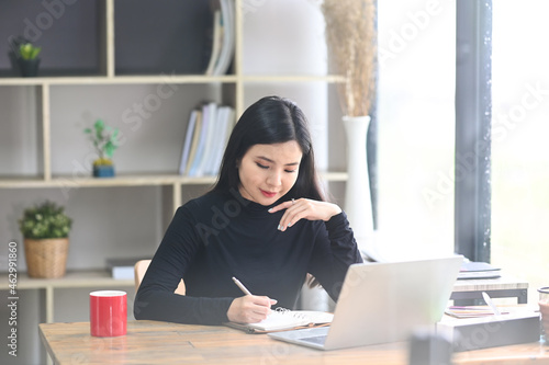 Beautiful young female designer working in creative office.