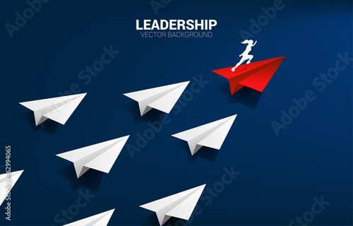 Silhouette of businesswoman running on red origami paper airplane leading group of white. Business Concept of leadership and vision mission.