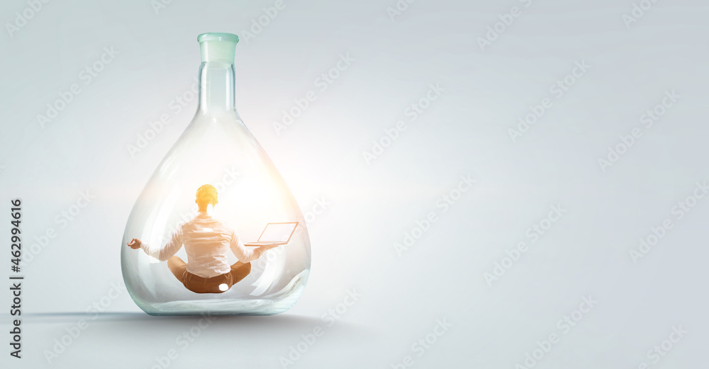 Business man doing yoga in lotus pose inside glass bottle Business man doing yoga in lotus pose inside glass bottle