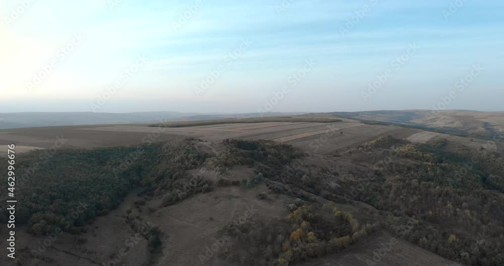 Green Forest At The Hill And The Vast Farmland Under Clear Blue Sky. aerial, hyperlapse Green Forest At The Hill And The Vast Farmland Under Clear Blue Sky. aerial, hyperlapse