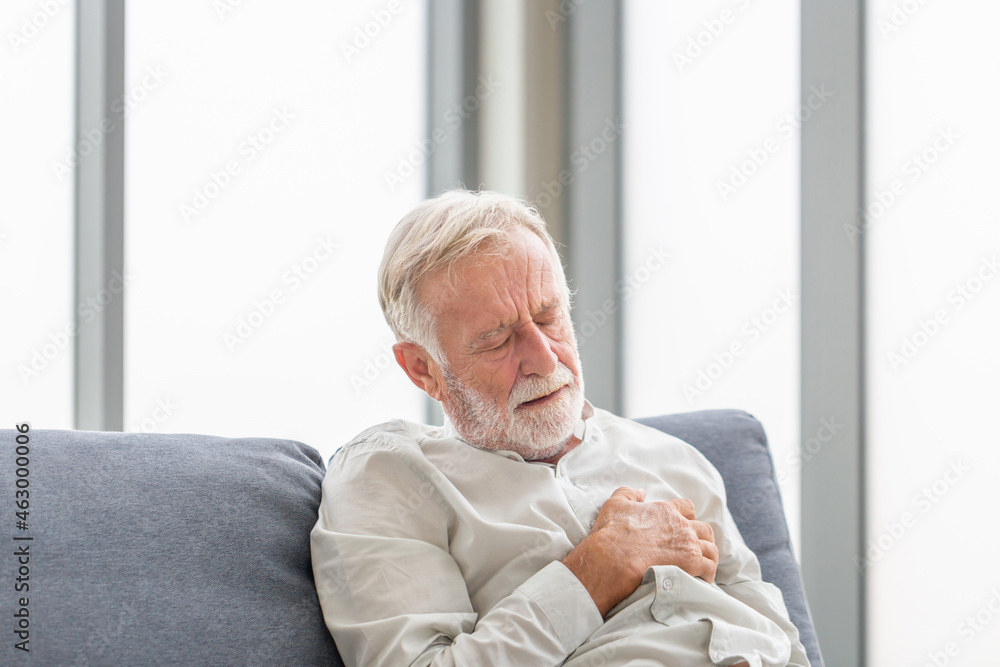 Close up of Senior man with pain on heart in living room, Mature man presses hand to chest has heart attack suffers from unbearable pain Close up of Senior man with pain on heart in living room, Mature man presses hand to chest has heart attack suffers from unbearable pain