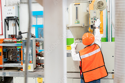 Female worker operating machinery in industrial plant