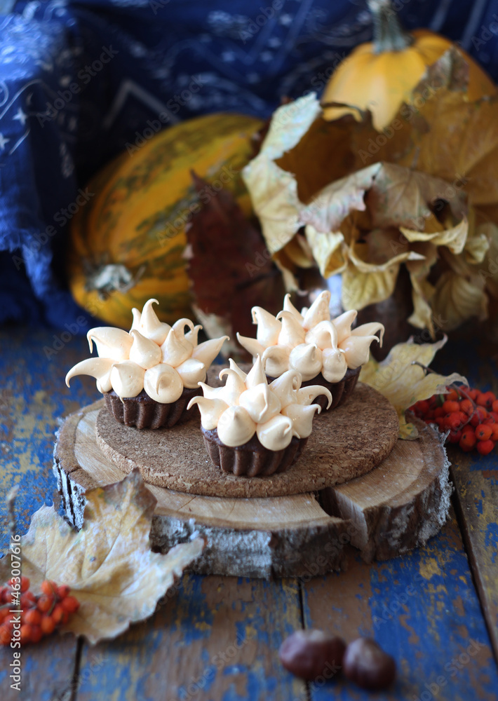 Fototapeta premium Cupcakes with cream on a pumpkin background for halloween