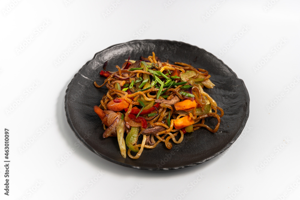 Lagman fried on a black plate on a white background Lagman fried on a black plate on a white background