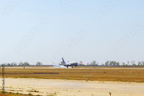 Passenger plane taking off from runway at airport on sunny day.