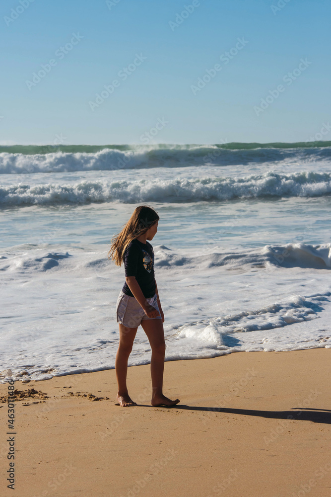 cute little girl playing with foam by the sea