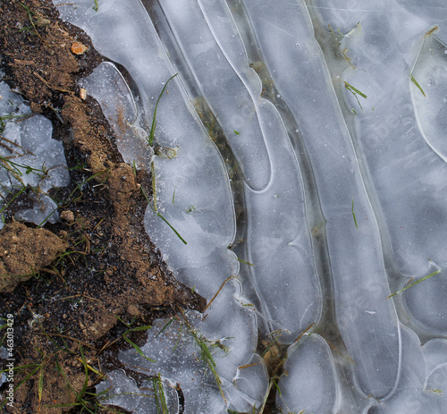 Ground with some grass and ice with air cavities photo