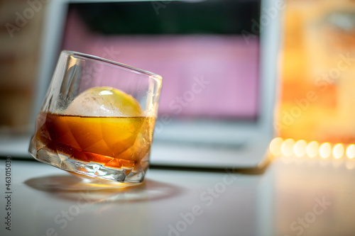 Americano filter coffee with ice ball over computer during working.