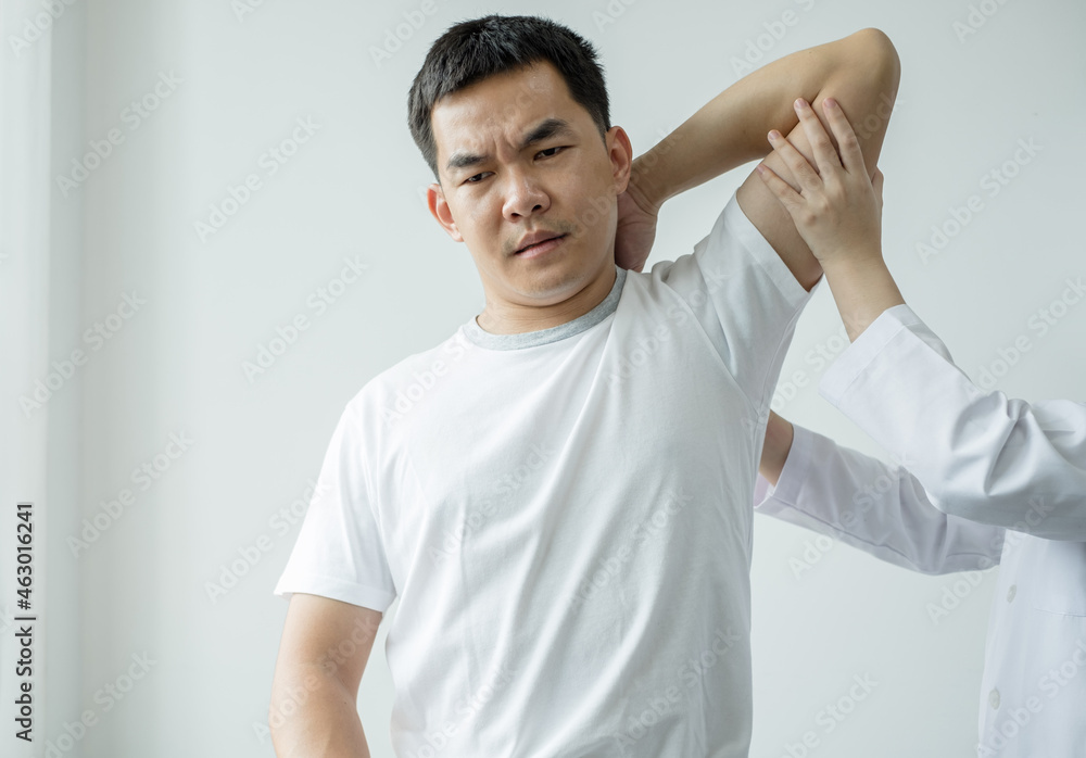 Female physiotherapists provide assistance to male patients with elbow injuries examine patients in rehabilitation centers. Physiotherapy concepts Female physiotherapists provide assistance to male patients with elbow injuries examine patients in rehabilitation centers. Physiotherapy concepts
