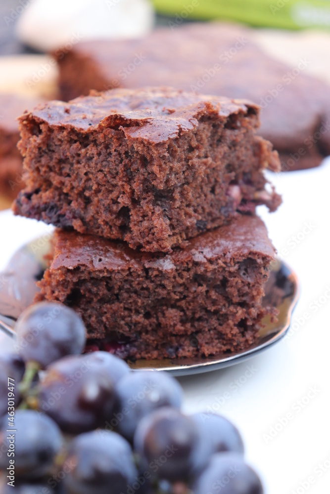 brownie cake with grapes, white background, on wooden slice brownie cake with grapes, white background, on wooden slice