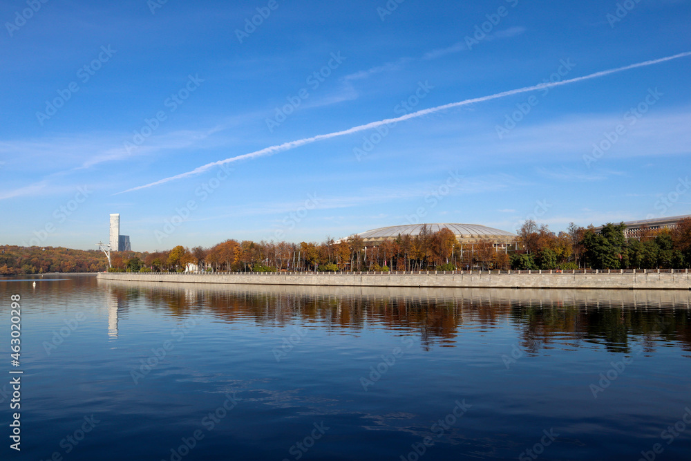 autumn landscape with Moscow river and Luzhniki stadium in october sunny mornig with blue sky and airplane contrail autumn landscape with Moscow river and Luzhniki stadium in october sunny mornig with blue sky and airplane contrail