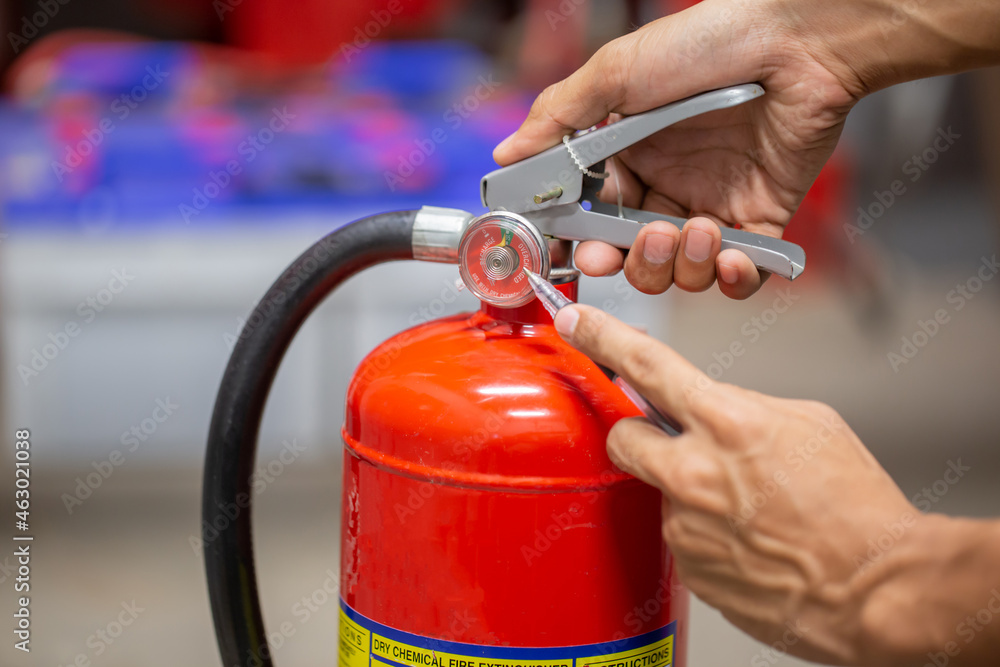 Engineer are checking and inspection a fire extinguishers tank in the fire control room for safety training and fire prevention. Engineer are checking and inspection a fire extinguishers tank in the fire control room for safety training and fire prevention.