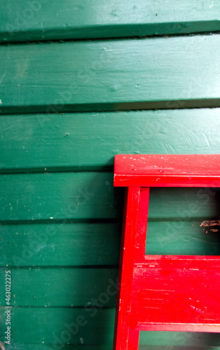 Red ladder on a green wall