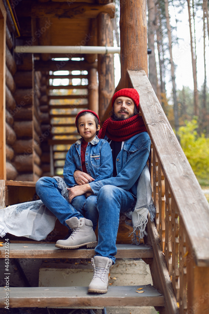 father and son in red hats and knitted scarves are sitting father and son in red hats and knitted scarves are sitting