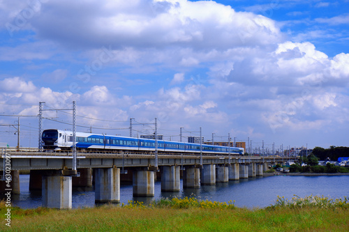 青空を背景に河を渡る列車