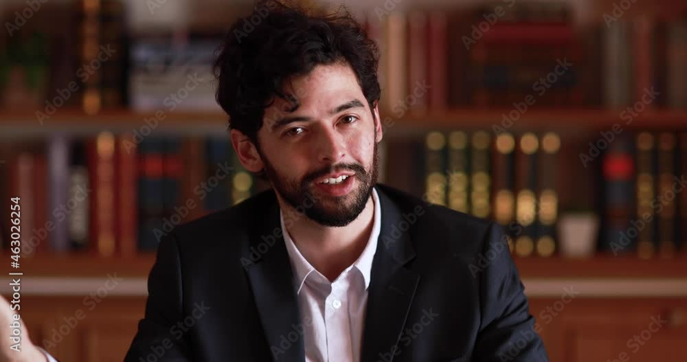 Happy caucasian businessman in suit sits in office and talk to audience or attendees via webcam camera with hands gesture. Online conference or job interview concept. Happy caucasian businessman in suit sits in office and talk to audience or attendees via webcam camera with hands gesture. Online conference or job interview concept.