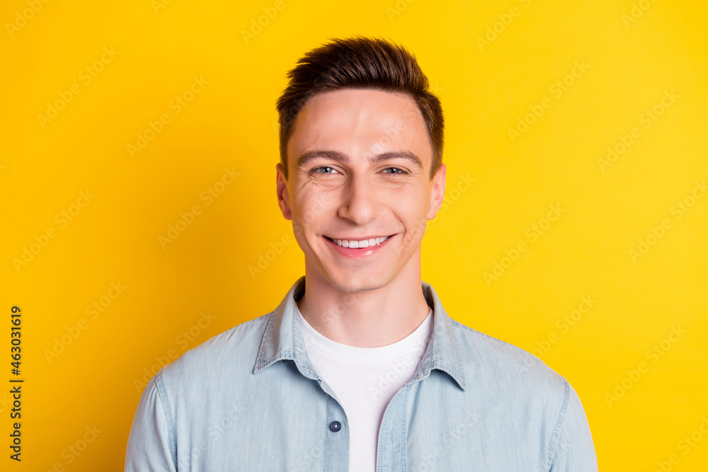 Portrait of attractive content cheerful guy wearing blue shirt isolated over bright yellow color background Portrait of attractive content cheerful guy wearing blue shirt isolated over bright yellow color background