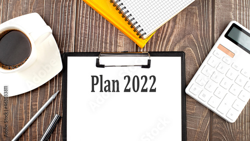 PLAN 2022 text on paper with coffee  calculator and notebook. Business concept