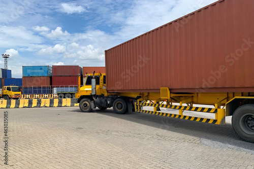 Trailer truck turning in the storage area under a cloudy blue sky