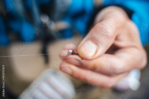 Close up of young fisherman s hands tying a Fly Fishing Knot. Fly fishing concept.