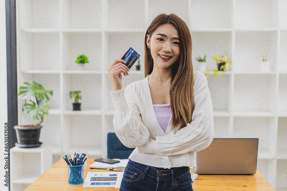 Portrait of a beautiful Asian woman holding a credit card, online shopping concept paying by credit card, young Asian business woman, modern female executive, business leader. Portrait of a beautiful Asian woman holding a credit card, online shopping concept paying by credit card, young Asian business woman, modern female executive, business leader.