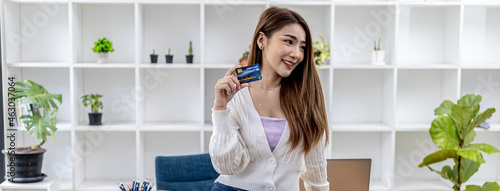 Portrait of a beautiful Asian woman holding a credit card  online shopping concept paying by credit card  young Asian business woman  modern female executive  business leader.